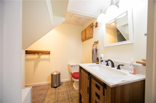 bathroom featuring baseboards, toilet, and vanity