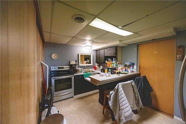 kitchen featuring electric range, light wood-style flooring, a paneled ceiling, and visible vents