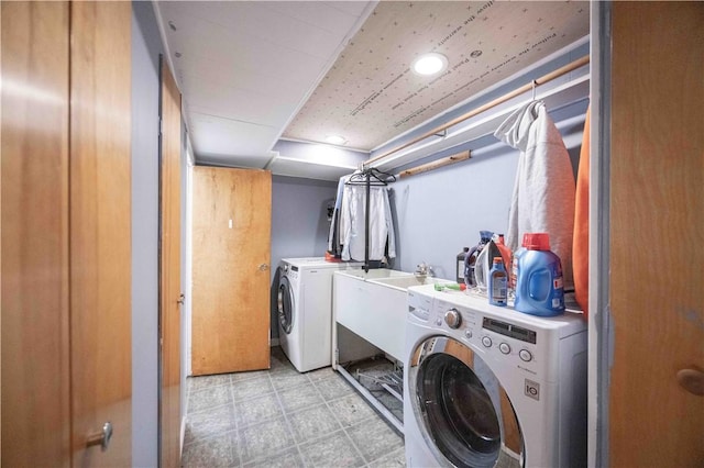 clothes washing area featuring laundry area, light floors, and washer and clothes dryer