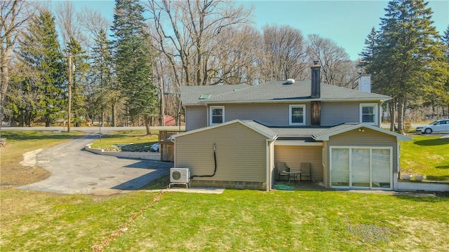 back of house featuring ac unit, a lawn, a chimney, and a patio area