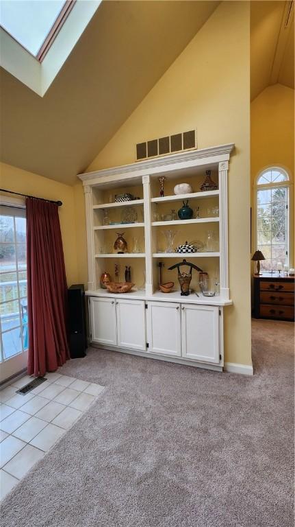 interior space with visible vents, a skylight, and carpet floors