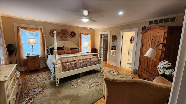 bedroom featuring visible vents, light wood-style flooring, ensuite bath, crown molding, and baseboards