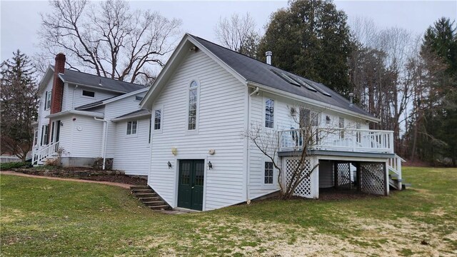 back of property featuring stairs, a deck, and a yard