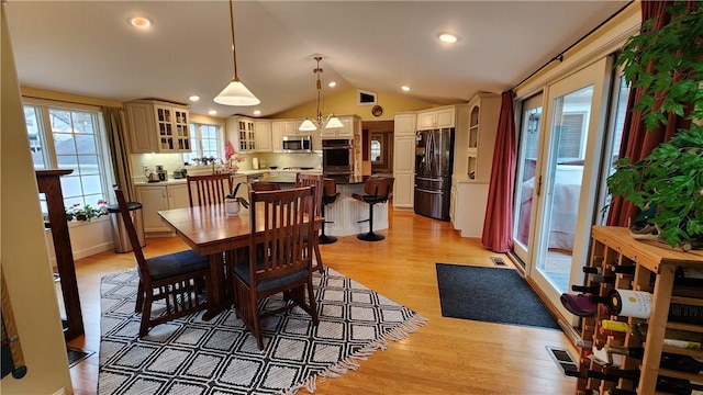 dining room with lofted ceiling, light wood-style flooring, recessed lighting, and visible vents