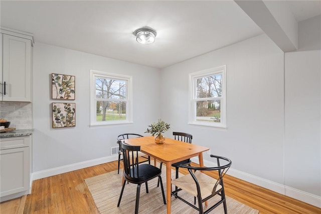 dining space featuring visible vents, baseboards, and light wood-style floors