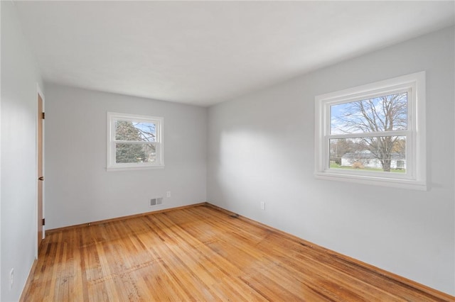 unfurnished room featuring light wood finished floors and visible vents