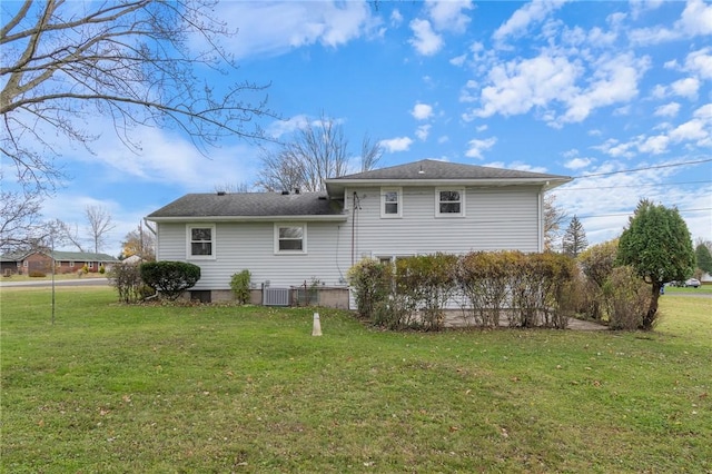 back of property with central AC and a yard