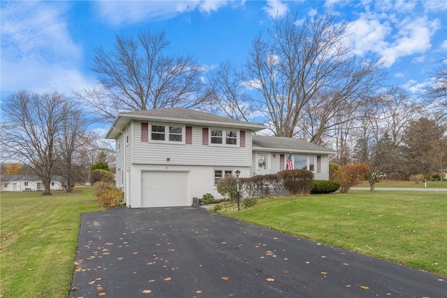 split level home featuring aphalt driveway, a garage, brick siding, and a front lawn