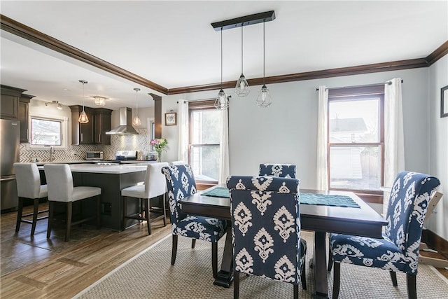 dining space with crown molding and wood finished floors