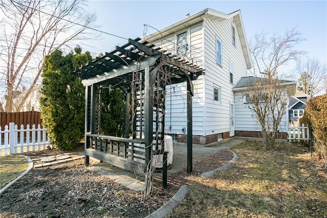 view of home's exterior featuring a patio, a pergola, and fence