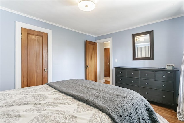 bedroom with crown molding and wood finished floors