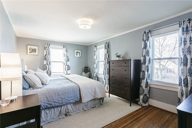 bedroom with baseboards, wood finished floors, and crown molding