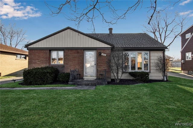 bungalow-style home with a front lawn, brick siding, and a shingled roof