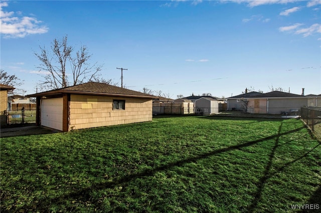 view of yard with a detached garage, an outdoor structure, and fence