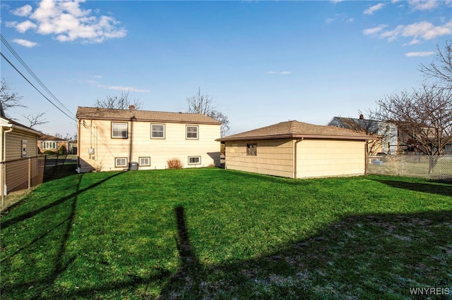 rear view of house featuring an outdoor structure, a lawn, a fenced backyard, and a chimney