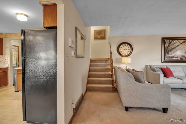 living area featuring stairway, light colored carpet, and baseboards