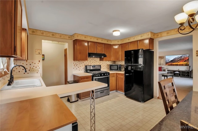 kitchen featuring a sink, tasteful backsplash, appliances with stainless steel finishes, and under cabinet range hood