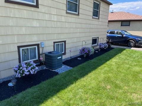 view of side of home with a lawn and cooling unit