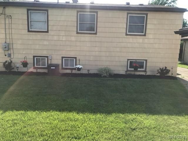 rear view of property with a lawn