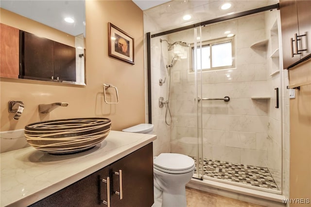 full bathroom featuring toilet, a stall shower, and vanity