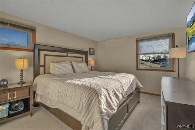 bedroom with baseboards and light carpet