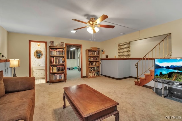 carpeted living room featuring stairs, a ceiling fan, and baseboards