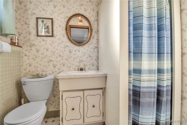 full bathroom featuring a shower with shower curtain, toilet, vanity, and wallpapered walls