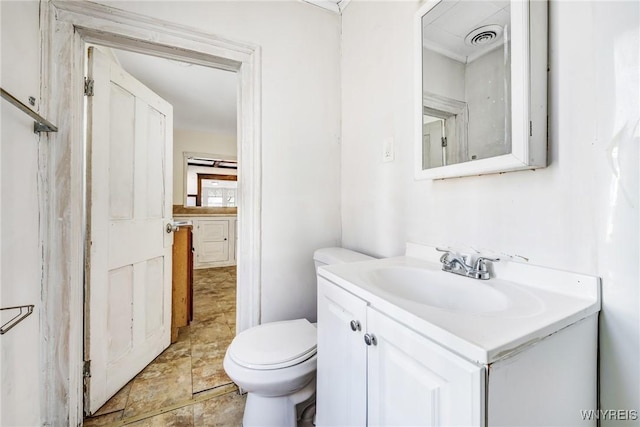 half bathroom with vanity, toilet, and visible vents