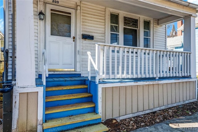 view of exterior entry featuring covered porch