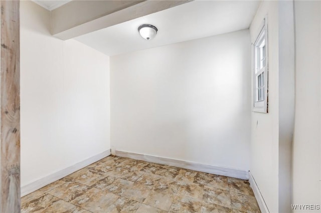 spare room with stone finish flooring and baseboards