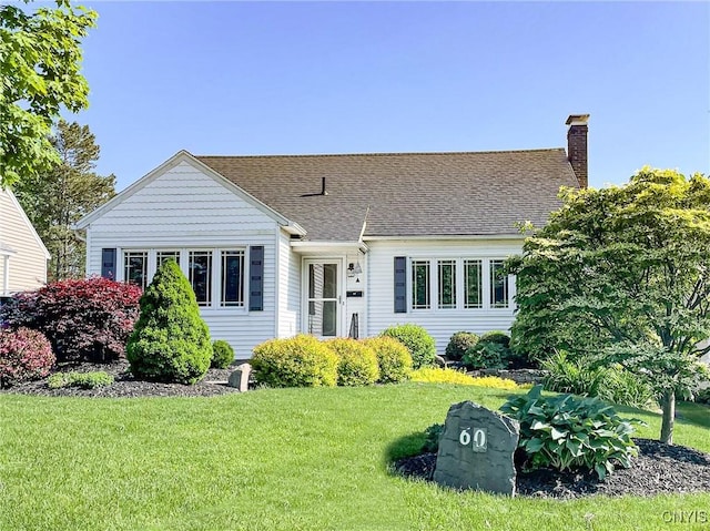 60 E Elizabeth St, Skaneateles, NY 13152 - view of front facade with a chimney, a front lawn, and roof with shingles