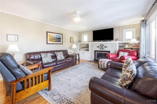 60 E Elizabeth St, Skaneateles, NY 13152 - living area featuring wood finished floors, a brick fireplace, ornamental molding, and ceiling fan