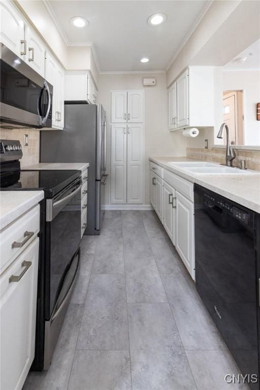 kitchen featuring ornamental molding, a sink, white cabinetry, stainless steel appliances, and light countertops