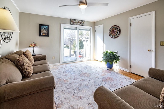 living room with ceiling fan, baseboards, ornamental molding, and wood finished floors