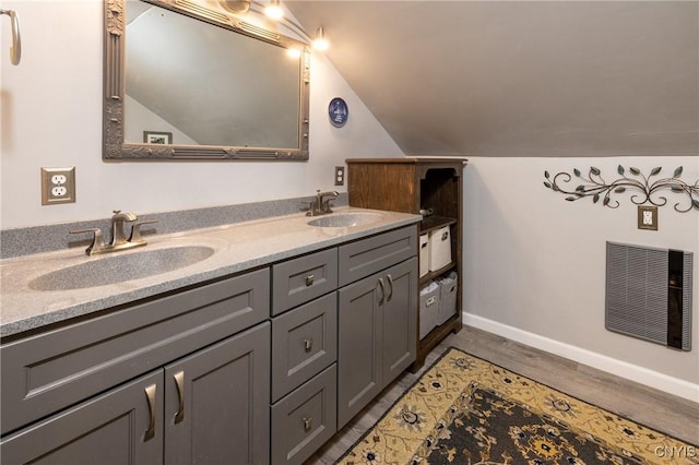 60 E Elizabeth St, Skaneateles, NY 13152 - bathroom featuring lofted ceiling, double vanity, baseboards, and wood finished floors