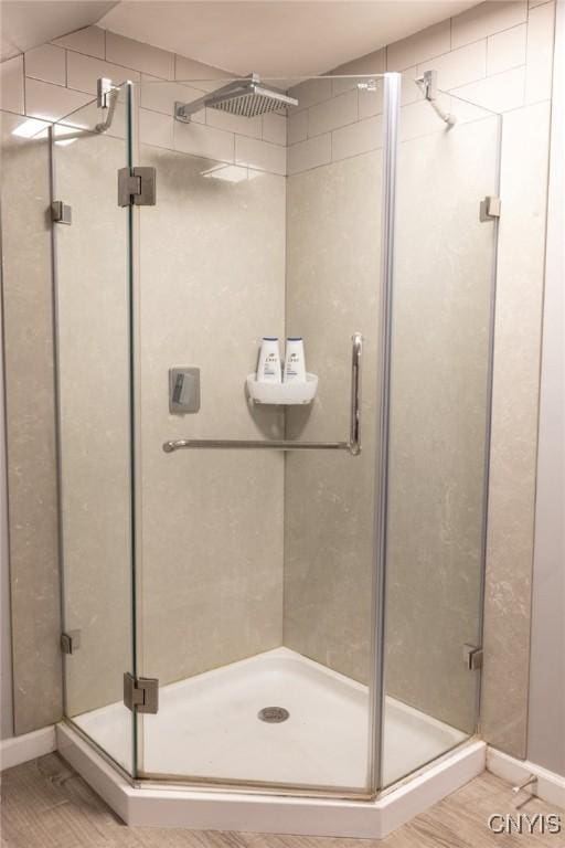 bathroom with a stall shower and wood finished floors