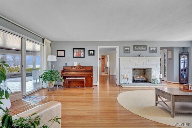 living area with light wood-style flooring, a fireplace, and a baseboard radiator