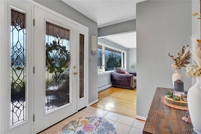 foyer entrance featuring baseboards, baseboard heating, and light tile patterned flooring