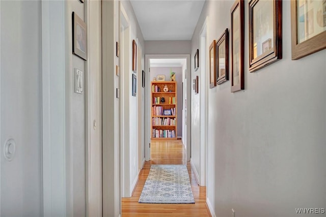 hallway featuring light wood-type flooring and baseboards