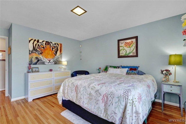 bedroom with baseboards and wood finished floors