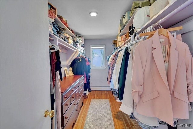 walk in closet featuring baseboard heating and wood finished floors