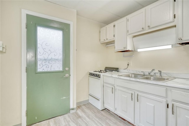 kitchen featuring white cabinets, light countertops, white range with gas stovetop, and a sink