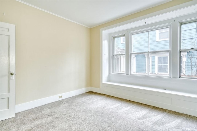 spare room with light colored carpet, baseboards, and ornamental molding