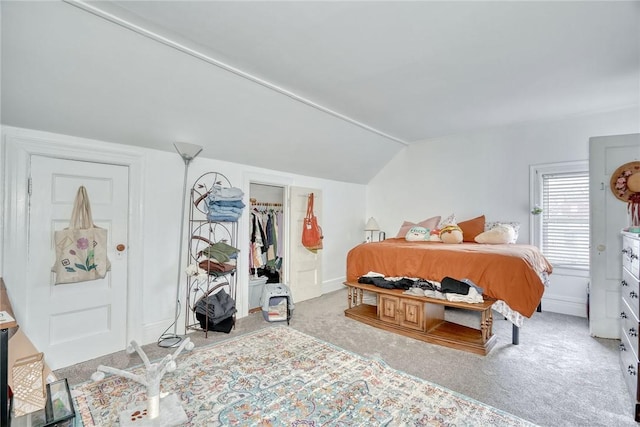 bedroom featuring baseboards, lofted ceiling, a spacious closet, and carpet flooring