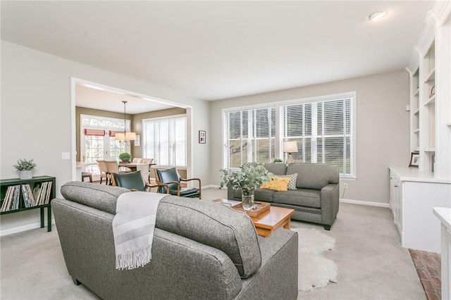 living room featuring baseboards and light carpet