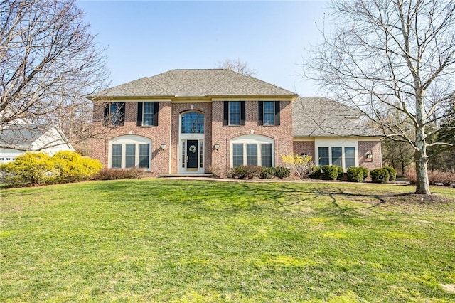 view of front of property featuring a front lawn and brick siding