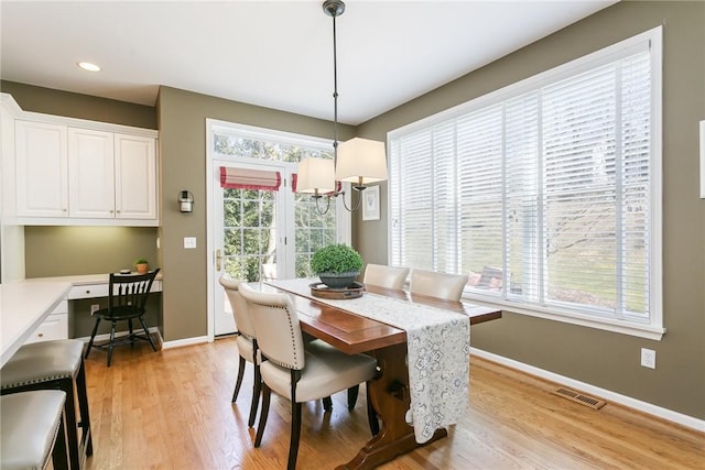 dining space with visible vents, baseboards, built in desk, recessed lighting, and light wood-style flooring