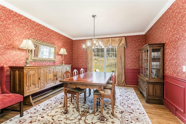 dining space with wainscoting, wallpapered walls, light wood-style flooring, and ornamental molding