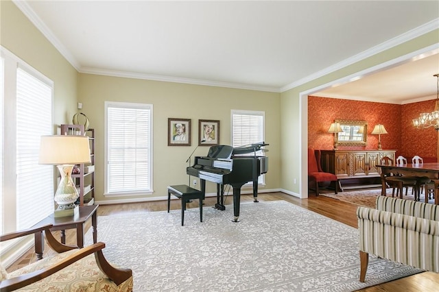 sitting room with baseboards, an inviting chandelier, wood finished floors, and ornamental molding