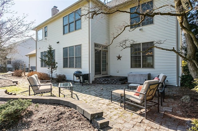 back of house featuring a chimney and a patio area